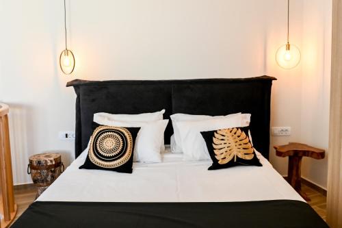 1 dormitorio con cama blanca y negra con almohadas en Residence by Georgia Studios, en Fira