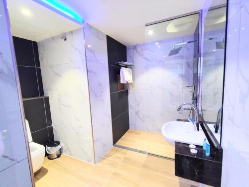 a bathroom with a glass shower and a sink at Nizwa Inn - نزوى إن in Nizwa