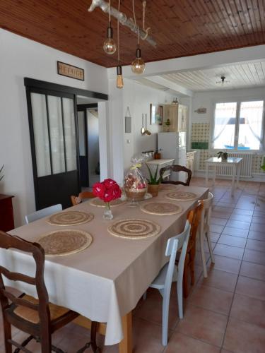 une cuisine et une salle à manger avec une table et des chaises dans l'établissement Les Crevettes, à LʼÉpine