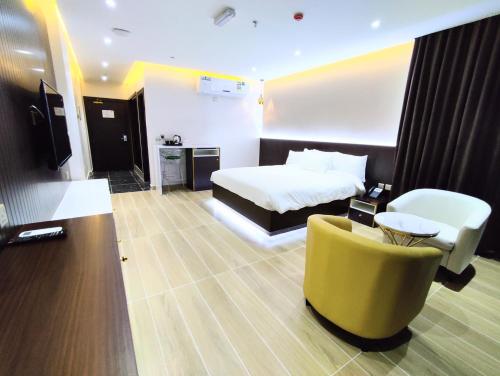 a hotel room with a bed and a yellow couch at Nizwa Inn - نزوى إن in Nizwa