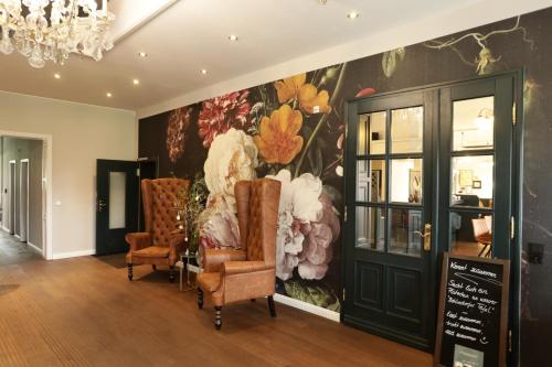 a room with chairs and a wall with a flower mural at Lieblingsplatz Bohlendorf Rügen in Wiek auf Rügen 