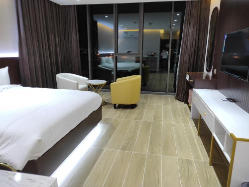 a hotel room with a bed and a yellow chair at Nizwa Inn - نزوى إن in Nizwa