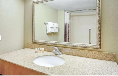a bathroom with a sink and a large mirror at La Quinta by Wyndham Minneapolis-Minnetonka in Minnetonka