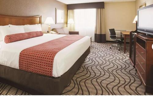 a hotel room with a large bed and a desk at La Quinta by Wyndham Minneapolis-Minnetonka in Minnetonka