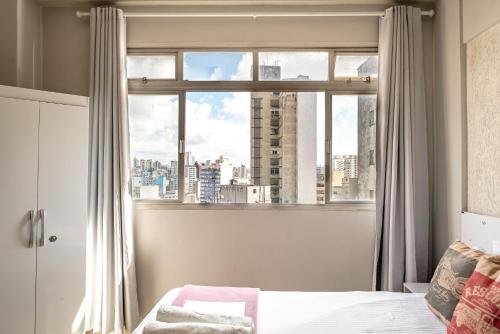 聖保羅的住宿－Pôr do sol 17º andar com vista da cidade，一间卧室设有窗户,享有城市美景