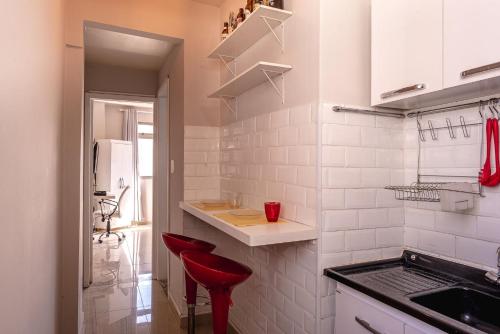 聖保羅的住宿－Pôr do sol 17º andar com vista da cidade，一间白色的厨房,在房间内配有红色凳子