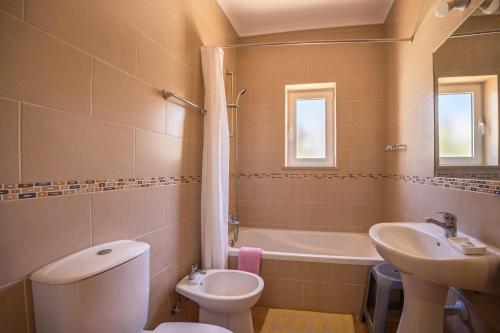 een badkamer met toilet, wastafel en bad bij Casa Bege T2 in Burgau
