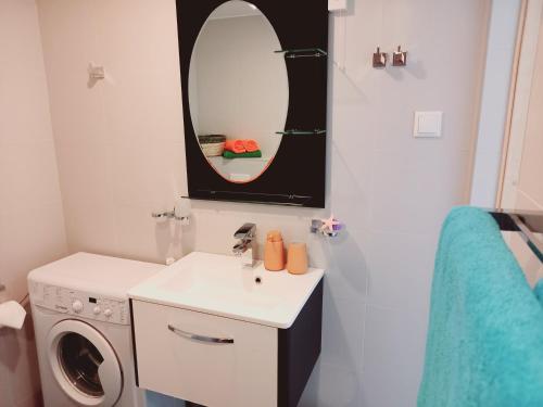 a bathroom with a sink and a washing machine at Studio SunSet in Pärnu