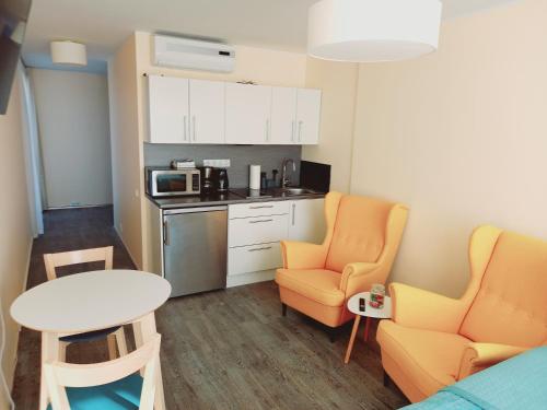 Habitación pequeña con 2 sillas, mesa y cocina en Studio SunSet, en Pärnu