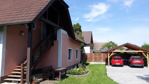 dom z dwoma samochodami zaparkowanymi na parkingu w obiekcie Ubytování u rybníka Svět w mieście Domanín