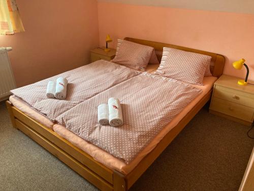 a bedroom with a bed with two slippers on it at Ubytování u rybníka Svět in Domanín
