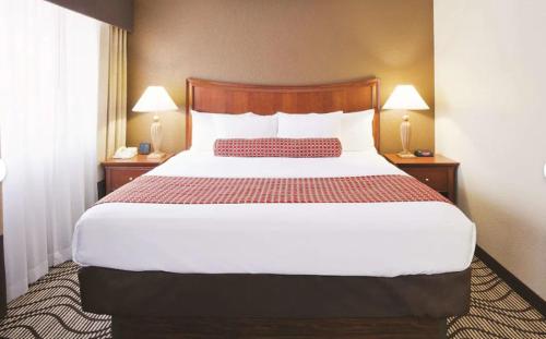 a large bed in a hotel room with two lamps at La Quinta by Wyndham Minneapolis-Minnetonka in Minnetonka