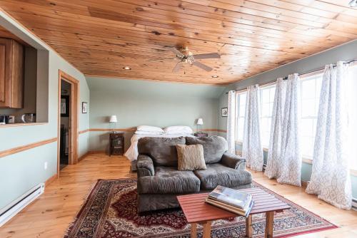 a living room with a couch and a wooden ceiling at The Loft at the Barn in Bolivar