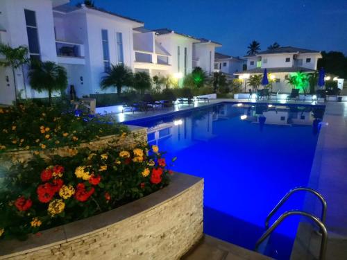 a swimming pool with flowers in front of a building at Casa Duplex Aconchegante de Frente para o Mar in Porto Seguro