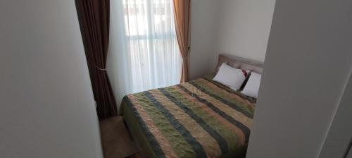 a small bedroom with a bed and a window at Квартира в Радуга WEST in Koshkolʼ