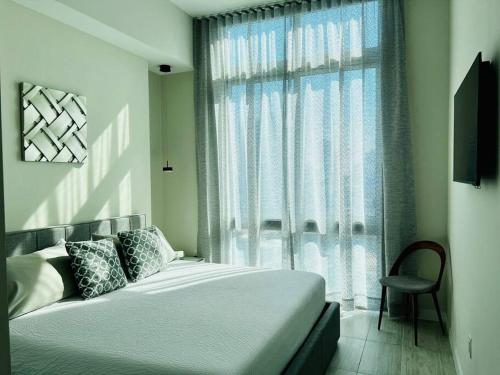 a bedroom with a bed and a window with a chair at BRAND NEW TOP FLOOR IN THE HEART OF MIAMI in Miami
