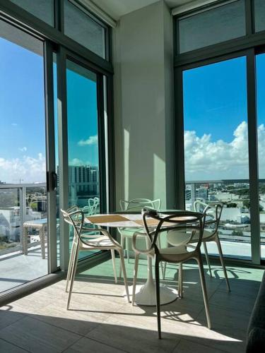 a table and chairs on a balcony with windows at BRAND NEW TOP FLOOR IN THE HEART OF MIAMI in Miami