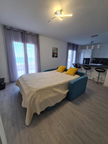 a bedroom with a large bed with yellow pillows at Logement 45 m2 vue mer in San-Martino-di-Lota