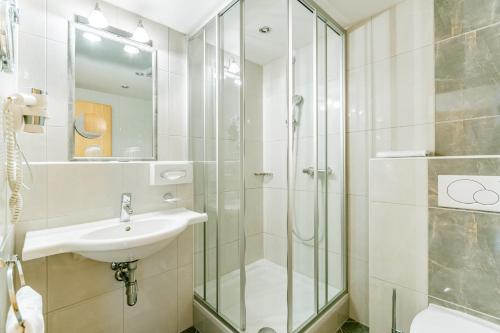 a bathroom with a sink and a shower at Hotel Huberhof in Innsbruck
