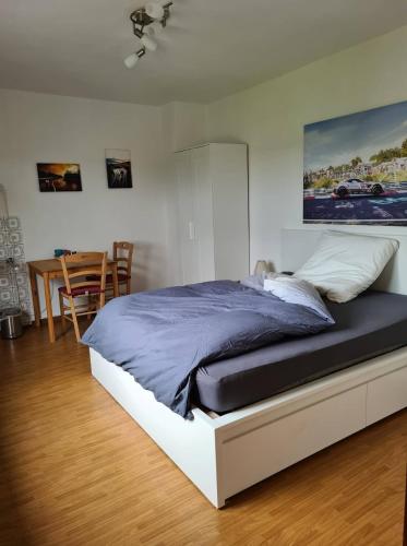 a bed in a bedroom with a table and chairs at Pension Larifari in Drees