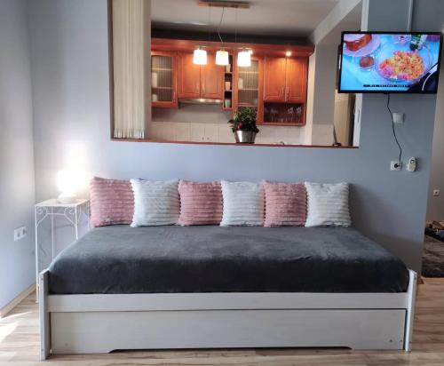 1 dormitorio con 1 cama y TV encima. en Sára Apartman Nyíregyháza, en Nyíregyháza