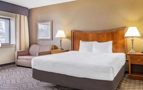 a hotel room with a large bed and a chair at La Quinta by Wyndham Minneapolis-Minnetonka in Minnetonka