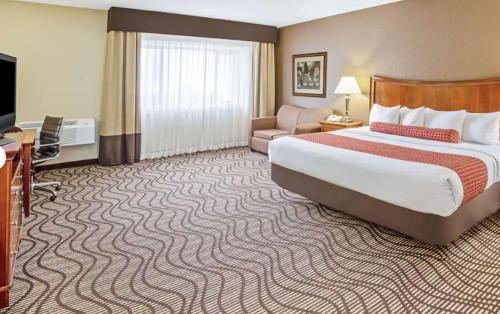 a hotel room with a large bed and a couch at La Quinta by Wyndham Minneapolis-Minnetonka in Minnetonka
