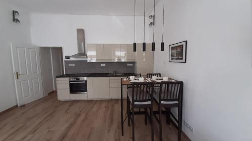 y cocina con mesa, sillas y fogones. en Pia's Gardenview, en Viena