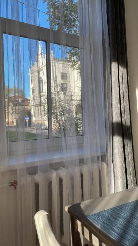 a window with a view of a building at Spacious Ausekla apartment in Liepāja