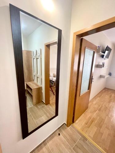 a mirror on a wall next to a hallway at Sunny in Varna City