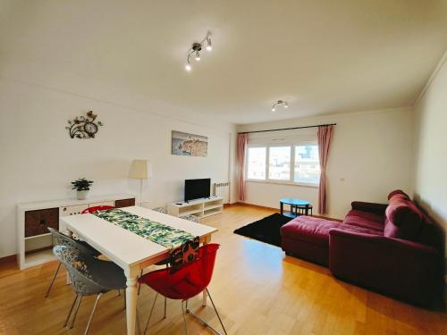 a living room with a table and a couch at Sunny Home Lisboa Expo, free parking in Lisbon