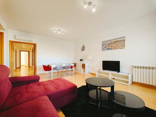 a living room with a red couch and a table at Sunny Home Lisboa Expo, free parking in Lisbon