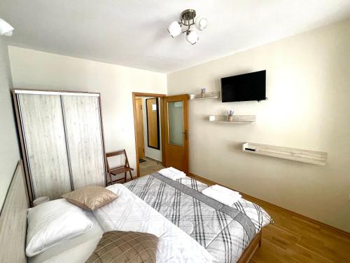 a bedroom with a bed and a flat screen tv at Sunny in Varna City