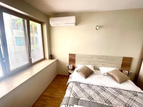 a bedroom with a bed and a large window at Sunny in Varna City