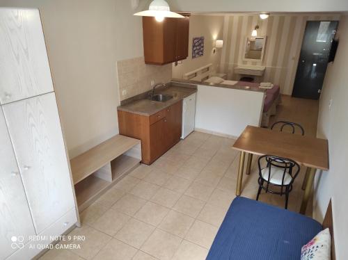 a small kitchen with a sink and a table at Blue Sky Apartments in Malia