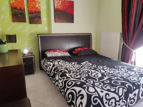 um quarto com uma cama com um edredão preto e branco em Διαμέρισμα για 4 με θέα θάλασσα σε ήσυχη γειτονιά em Chalkida