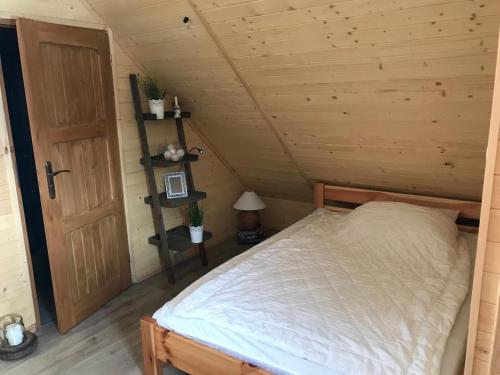 sypialnia z łóżkiem i drewnianym sufitem w obiekcie MAZUR 35 w mieście Szyldak
