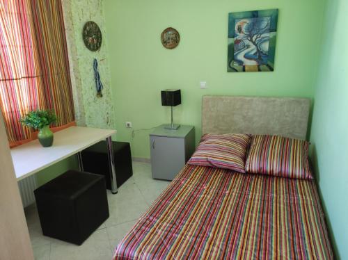um pequeno quarto com uma cama e uma secretária em Διαμέρισμα για 4 με θέα θάλασσα σε ήσυχη γειτονιά em Chalkida