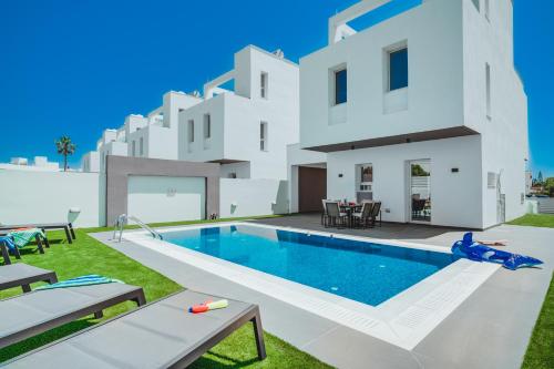 an image of a villa with a swimming pool at Stay in Style in Modern 3 Bedroom Villas Near Nissi Beach & Square in Ayia Napa