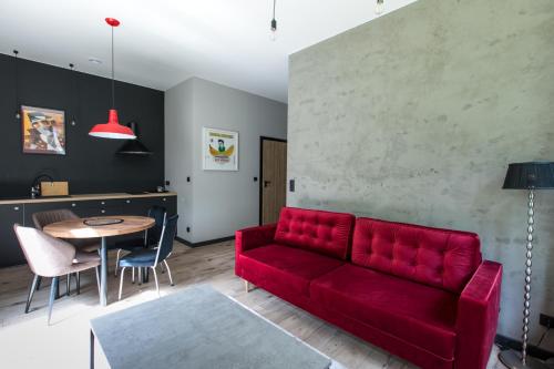 a living room with a red couch and a table at Pasjonat Tu in Tuczno