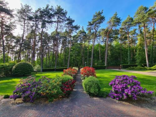 a garden with colorful flowers on a brick path at Pasjonat Tu in Tuczno
