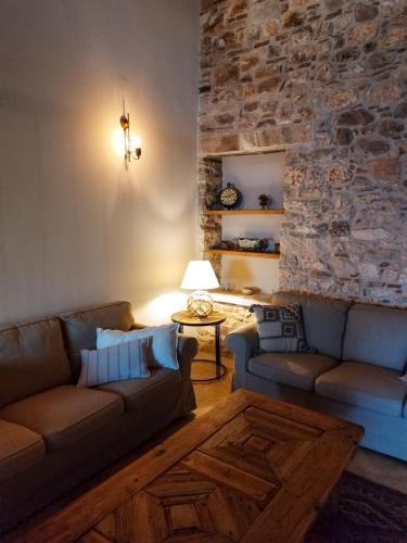 a living room with two couches and a stone wall at Aura di mare luxury house Thassos in Limenas