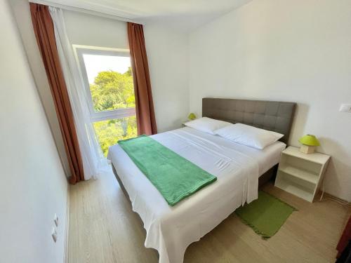 1 dormitorio con 1 cama grande y ventana en Villa Evita Apartments, en Prožura