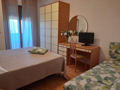 1 dormitorio con escritorio, 1 cama y 1 silla en Hotel Tirrenia, en Chianciano Terme