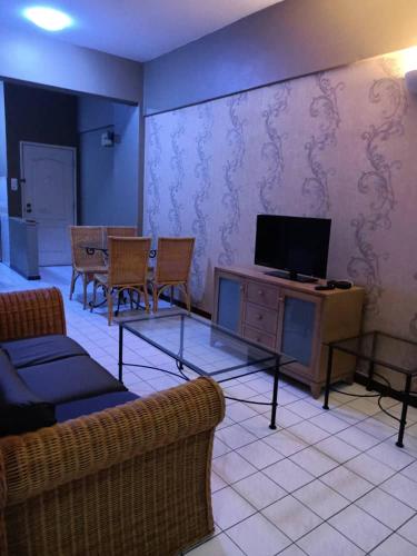 a living room with a tv and a table and chairs at Port Dickson Seaview Homestay in Port Dickson