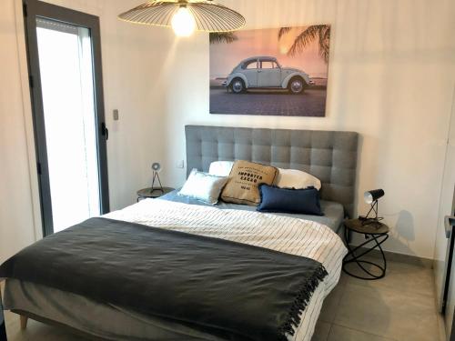 a bed in a bedroom with a picture of a car at Superbe appartement sur le port, jacuzzi, piscine in Porto-Vecchio
