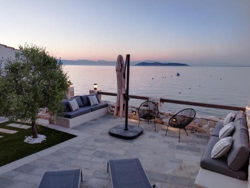 a patio with chairs and a view of the water at Aura di mare luxury house Thassos in Limenas