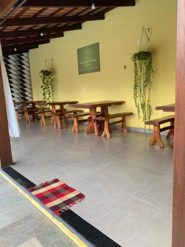 a row of wooden tables in a room at Pousada Portal do Cerrado in Pirenópolis