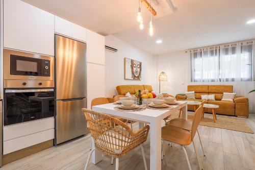 kuchnia i salon z białym stołem i krzesłami w obiekcie Family HOME SUITS Encantos de Sevilla w Sewilli