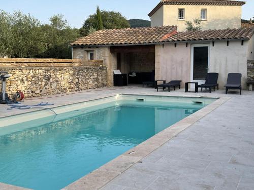 une piscine devant une maison dans l'établissement Captivating 2-Bed, 1 bath Cottage, Private Garden & Shared Pool in Sauve, à Sauve